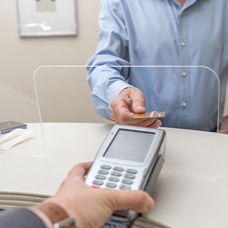 A man using his credit card to pay for dental care