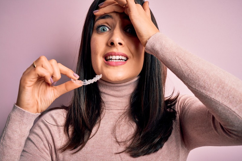 Patient with bruxism holding their Invisalign aligner